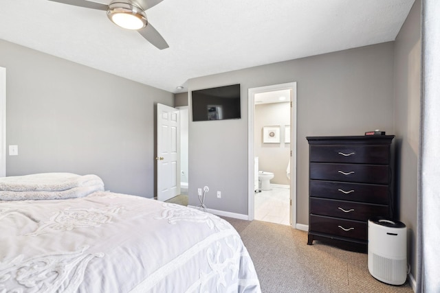 bedroom with light colored carpet, ceiling fan, and ensuite bath