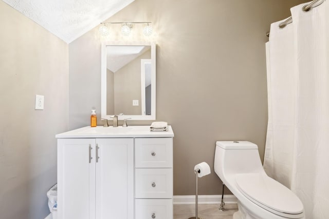 bathroom featuring vanity, toilet, vaulted ceiling, and a textured ceiling