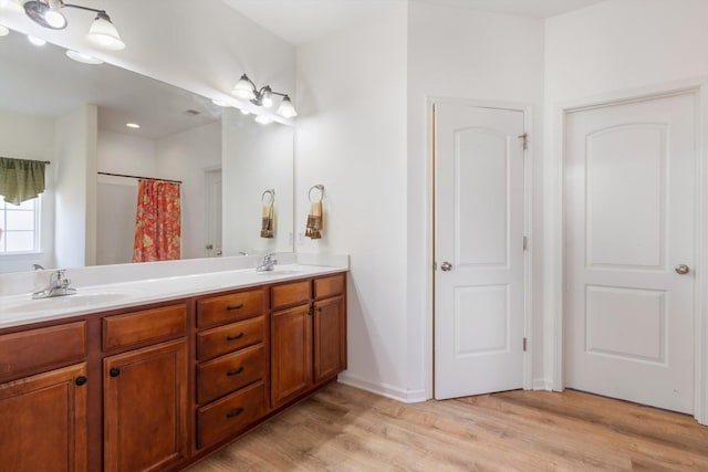 bathroom featuring hardwood / wood-style flooring, vanity, and curtained shower