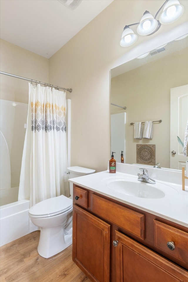 full bathroom with vanity, hardwood / wood-style floors, shower / bath combination with curtain, and toilet