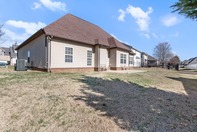 back of property featuring a lawn, a patio, and central air condition unit