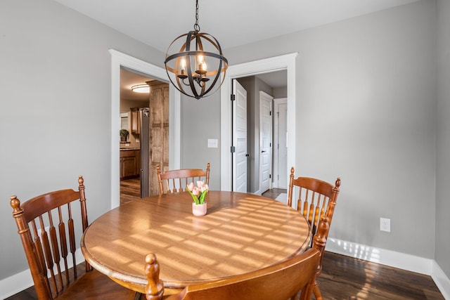 dining space featuring an inviting chandelier and dark wood-type flooring