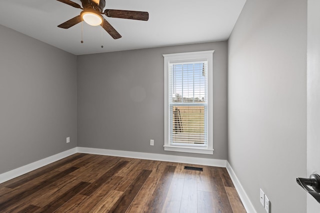 empty room with dark hardwood / wood-style flooring and ceiling fan