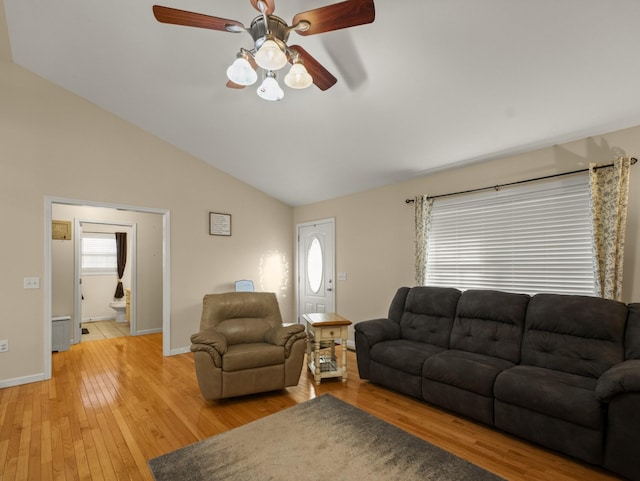 living room with ceiling fan, lofted ceiling, and light wood-type flooring