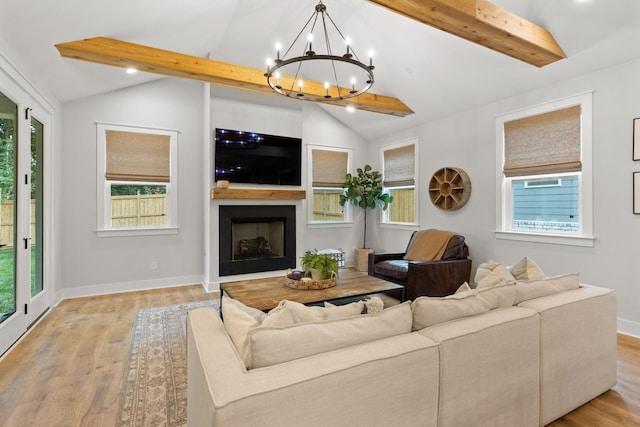 living room featuring light hardwood / wood-style flooring, lofted ceiling with beams, and a chandelier