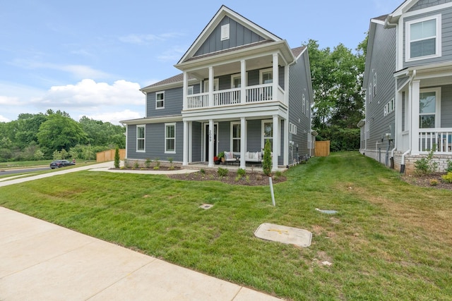 view of front of house with a porch, a balcony, and a front lawn