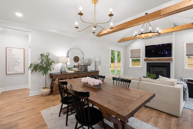 dining space featuring lofted ceiling with beams, light hardwood / wood-style flooring, and a notable chandelier