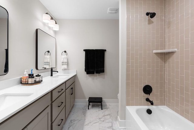 full bathroom with tiled shower / bath, vanity, and toilet