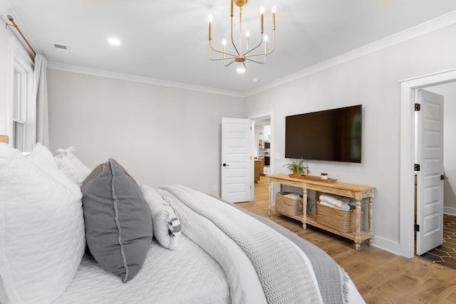 bedroom featuring hardwood / wood-style flooring, crown molding, and a chandelier