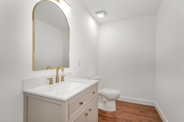 bathroom with hardwood / wood-style flooring, vanity, and toilet