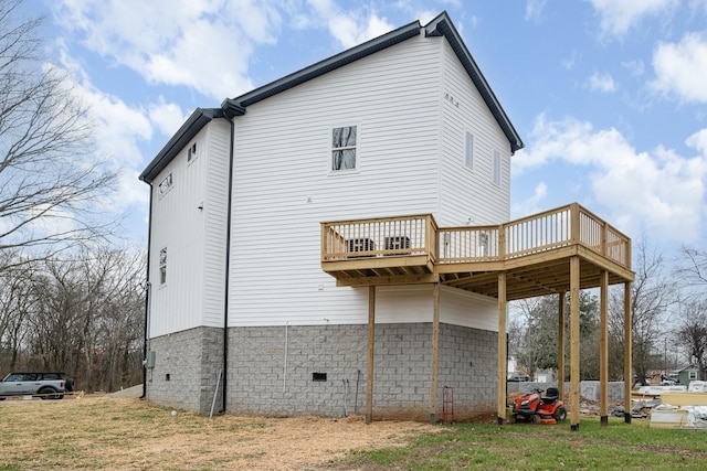 rear view of property with a wooden deck and a lawn