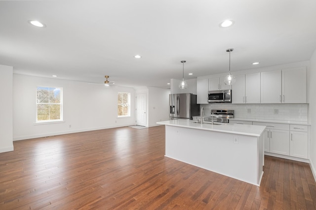 kitchen featuring appliances with stainless steel finishes, a kitchen island with sink, and white cabinets