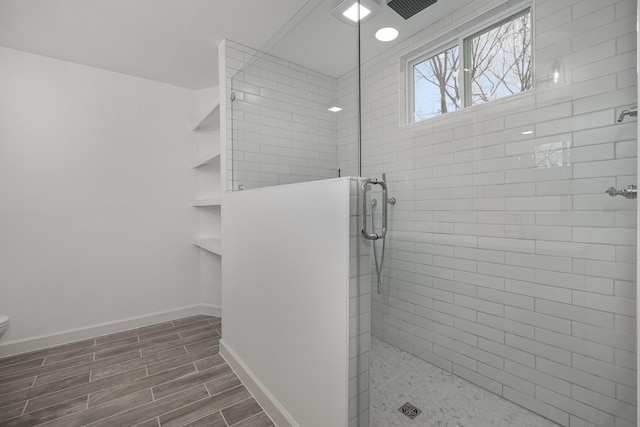 bathroom with a shower with door and toilet