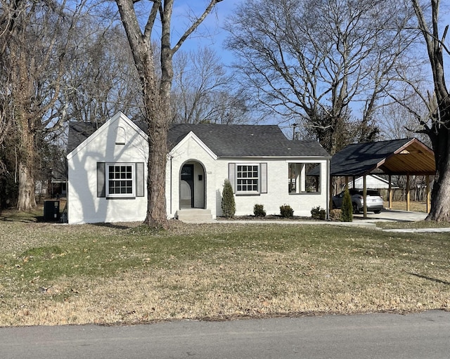 view of front of property with a front lawn, a carport, and central air condition unit