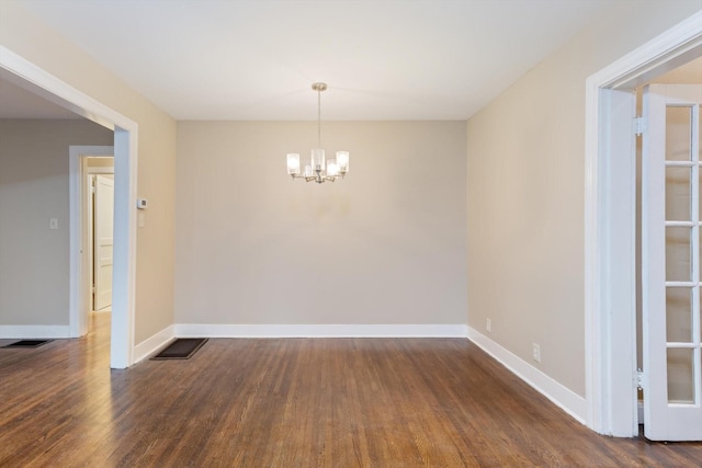 unfurnished dining area with an inviting chandelier and dark hardwood / wood-style floors