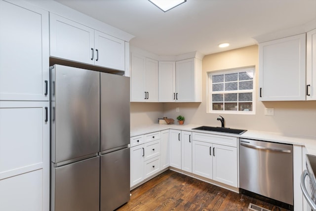 kitchen with white cabinetry, appliances with stainless steel finishes, dark hardwood / wood-style flooring, and sink