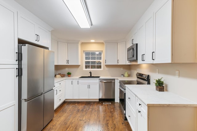 kitchen featuring sink, dark hardwood / wood-style floors, white cabinets, and appliances with stainless steel finishes