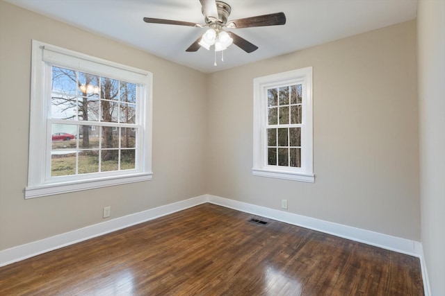 spare room with ceiling fan, a healthy amount of sunlight, and dark hardwood / wood-style flooring