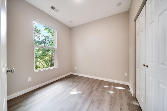 unfurnished bedroom featuring a closet and light hardwood / wood-style flooring