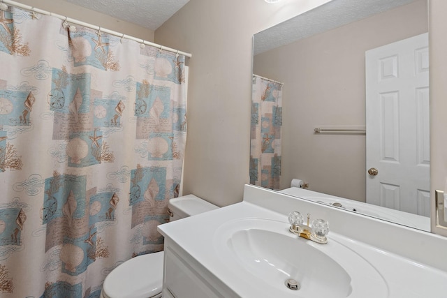 bathroom featuring vanity, a shower with curtain, toilet, and a textured ceiling