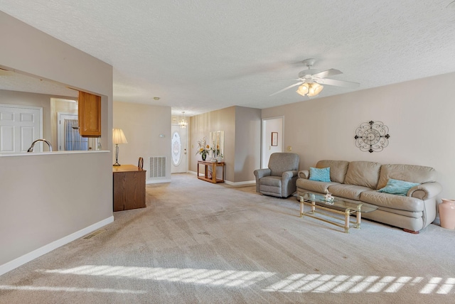 carpeted living room featuring ceiling fan and a textured ceiling