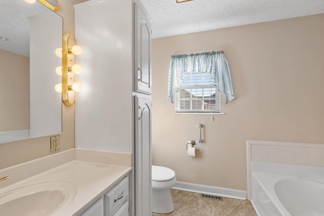 bathroom with vanity, toilet, a bath, and a textured ceiling