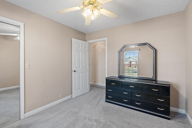 carpeted bedroom featuring ceiling fan, a closet, and a textured ceiling