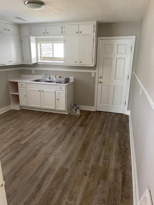 kitchen with dark hardwood / wood-style flooring, sink, and white cabinets