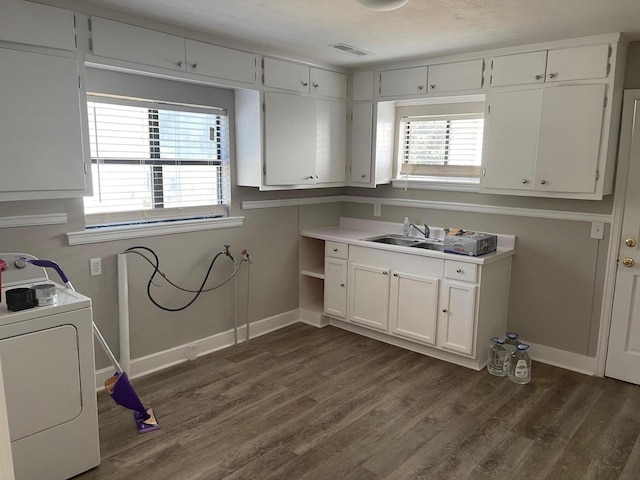 clothes washing area with sink, washer / dryer, dark hardwood / wood-style floors, and a healthy amount of sunlight