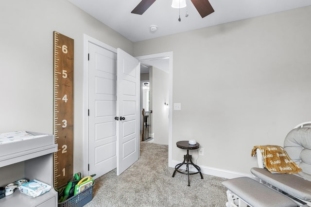 living area featuring light carpet and ceiling fan