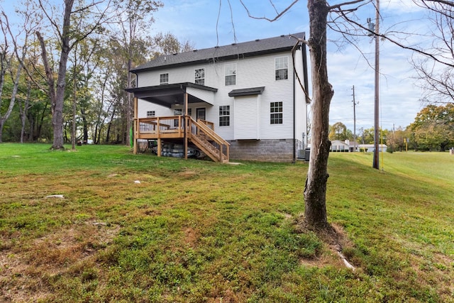 rear view of house featuring a wooden deck and a yard