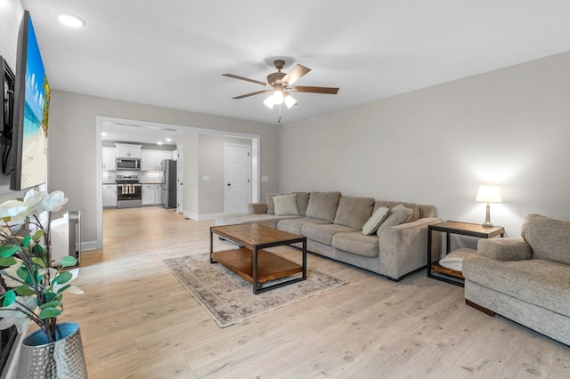 living room with ceiling fan and light wood-type flooring