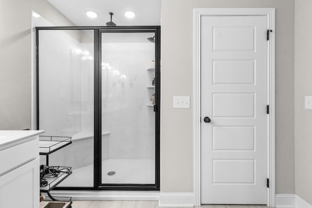 bathroom featuring vanity and a shower with door