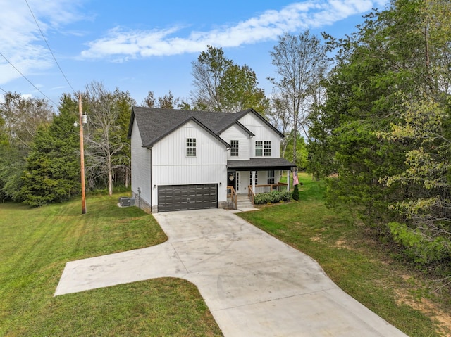 view of front of house featuring central AC unit, a garage, a front lawn, and covered porch