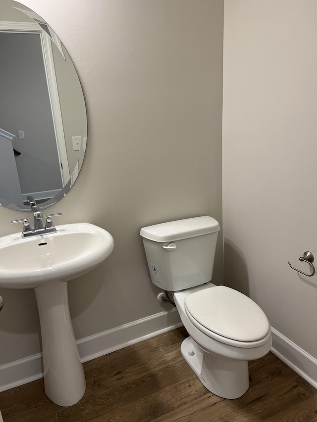 bathroom with hardwood / wood-style flooring and toilet