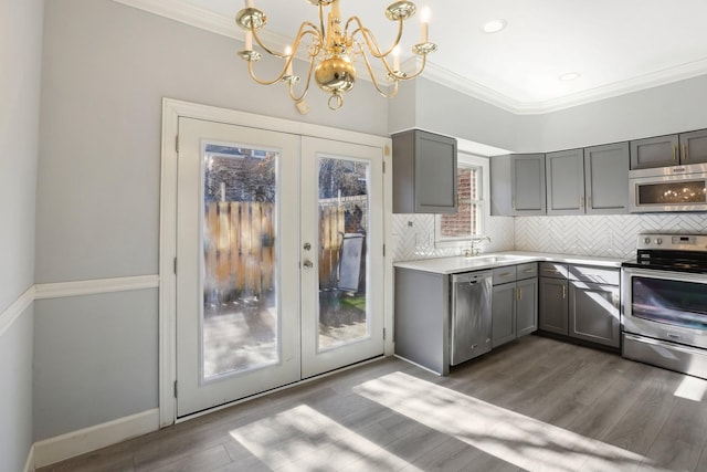 kitchen featuring decorative light fixtures, decorative backsplash, stainless steel appliances, dark wood-type flooring, and french doors