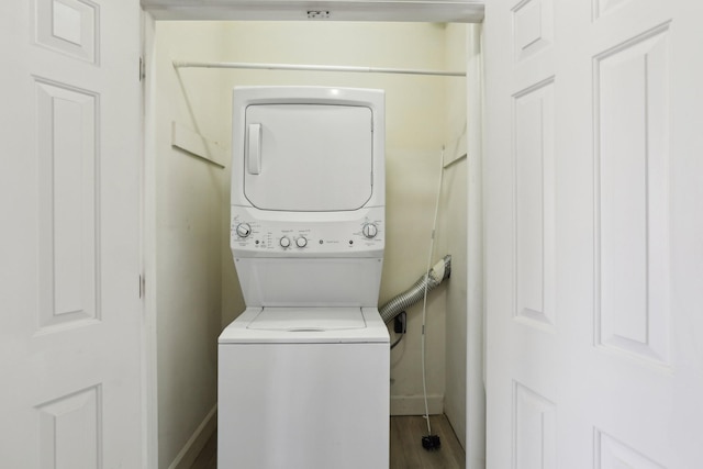 laundry room with stacked washer and clothes dryer and hardwood / wood-style floors