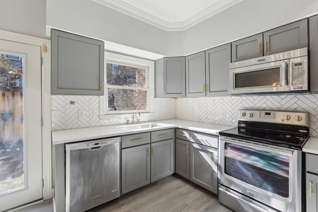 kitchen featuring light hardwood / wood-style floors, stainless steel appliances, gray cabinets, and sink