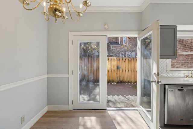 doorway featuring light hardwood / wood-style floors, a notable chandelier, ornamental molding, and french doors