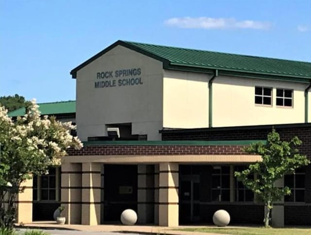 exterior space featuring metal roof, brick siding, and stucco siding