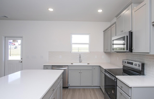 kitchen with visible vents, appliances with stainless steel finishes, gray cabinets, and a sink