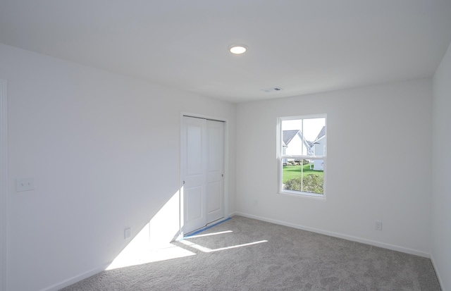 carpeted empty room with recessed lighting, visible vents, and baseboards