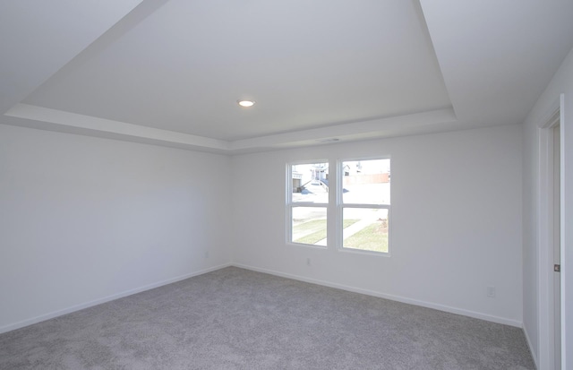 unfurnished room featuring carpet floors, baseboards, and a tray ceiling