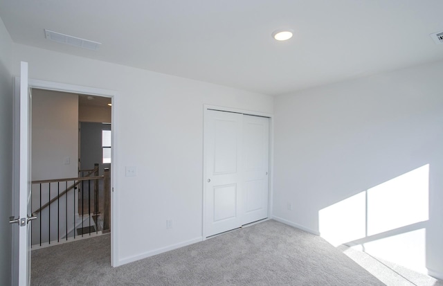 unfurnished bedroom featuring carpet, visible vents, and baseboards