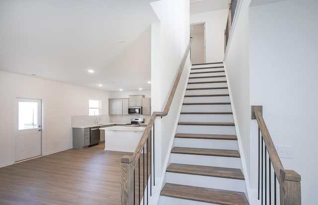 stairs featuring recessed lighting and wood finished floors