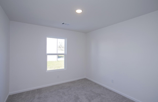 spare room featuring recessed lighting, carpet flooring, visible vents, and baseboards