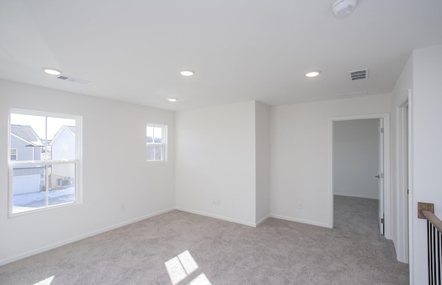 carpeted spare room featuring recessed lighting, visible vents, and baseboards