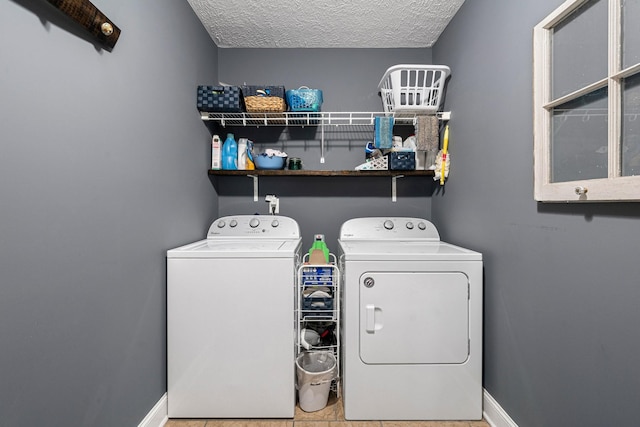 washroom featuring washing machine and dryer, a textured ceiling, and light tile patterned floors