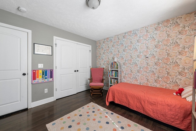 bedroom featuring dark hardwood / wood-style flooring, a closet, and a textured ceiling