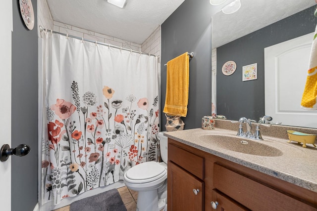 bathroom with vanity, toilet, tile patterned flooring, and a textured ceiling